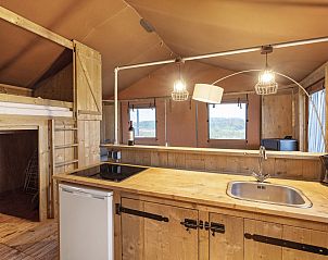 Comfortable bed in Sluftervallei glamping lodge, Texel, with natural surroundings.