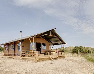Interior of Sluftervallei safari tent, Texel, with cozy sitting area and view.