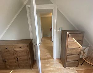 Gemtlicher Innenraum mit Holzmbeln im Ferienhaus in De Cocksdorp, Texel, Watteninseln.