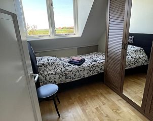 Schlafzimmer mit Einzelbett in Ferienhaus in De Cocksdorp, Texel, Waddeninseln mit Aussicht.