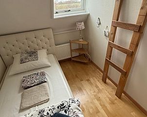 Stilvolles Schlafzimmer mit dekorativer Leiter im Ferienhaus in De Cocksdorp, Texel, Watteninseln.