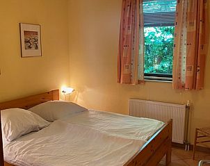 Zweites Schlafzimmer des Ferienhauses Slufterhoek 128 in De Cocksdorp Texel, mit groem Fenster und Bett.