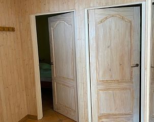 Diele im Ferienhaus Slufterhoek 128, De Cocksdorp Texel, mit Holztren und gefliestem Boden.