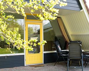 Terrasse des Bungalows Pier 53 in De Cocksdorp, Texel, mit Sitzgelegenheiten und Blick auf die Natur.