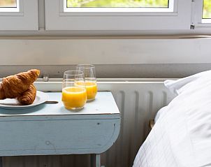 Frhstck auf dem Nachttisch im Bungalow Pier 53, De Cocksdorp, Texel, mit frischem Orangensaft und Croissants.