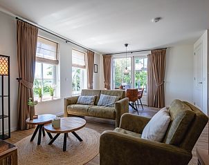 Gemtliches Wohnzimmer der Wohnung A in De Cocksdorp, Texel, mit viel Tageslicht und bequemen Sitzgelegenheiten.