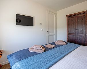 Modernes Schlafzimmer in Appartement A, De Cocksdorp, Texel, mit Fernseher und viel Stauraum fr Gste.