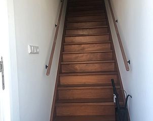 Houten trap in Appartement C, De Cocksdorp, Texel, leidt naar de bovenverdieping.