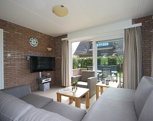 Gezellige woonkamer in Bungalow De Witte Hoek 6 Pers., De Cocksdorp, Texel met comfortabel interieur en tuinzicht.