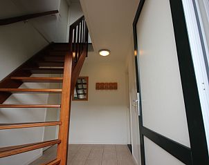 Houten trap in de hal van Bungalow De Witte Hoek 6 Pers., De Cocksdorp, Texel met toegang tot bovenverdieping.