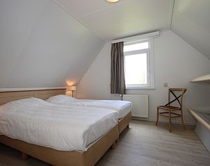 Zolderkamer in Bungalow De Witte Hoek 6 Pers., De Cocksdorp, Texel met twee bedden en veel natuurlijk licht.