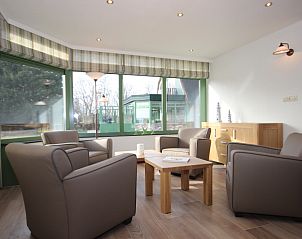 Helle Sitzecke im Wintergarten der Villa De Witte Hoek, Ferienhaus auf Texel mit Blick auf den Garten.