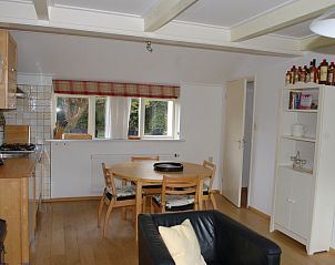 Dining area and kitchen in vacation home Kikkertstraat 067, De Cocksdorp, Texel, with wooden furniture.