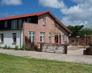 Spacious outdoor area of vacation home Cottage in De Cocksdorp, Texel, with green surroundings.
