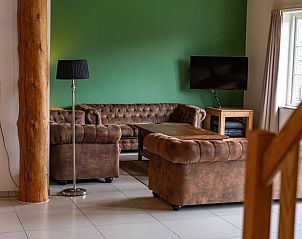 Cozy sitting area in Cottage in De Cocksdorp, Texel, with green wall and modern amenities.