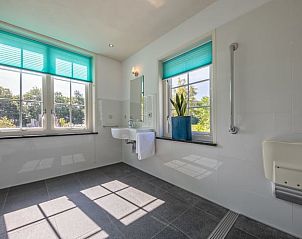 Bright bathroom in Cottage in De Cocksdorp, Texel, with large window and modern sink.