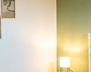 Attractive bedroom in cottage in De Cocksdorp, Texel, with art on the wall and soft light.