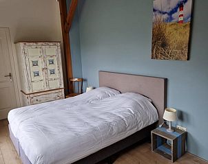 Bedroom in Cottage in De Cocksdorp, Texel, with painting of lighthouse and country style.
