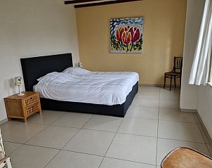 Spacious bedroom in cottage in De Cocksdorp, Texel, with colorful painting and lots of light.