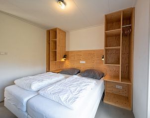 Hauptschlafzimmer im Bungalowpark Tamarisk - Bungalow 200 - Ties, Texel mit bequemen Betten und Stauraum.