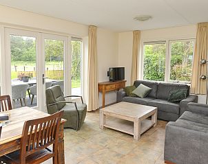 Cozy living room in Vuurtorenwachter, De Cocksdorp, Texel with comfortable furniture and garden views.