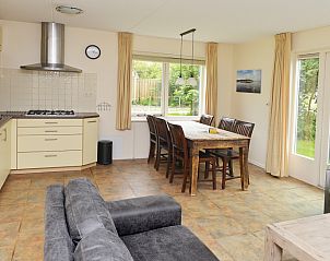 Open kitchen and dining area in Vuurtorenwachter, De Cocksdorp, Texel overlooking green surroundings.