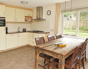 Spacious kitchen in vacation home Vuurtorenwachter, De Cocksdorp, Texel with dining area and garden view.