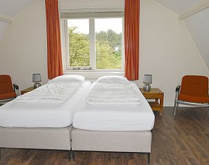 Bright bedroom with double bed in Vuurtorenwachter, De Cocksdorp, Texel with views of nature.
