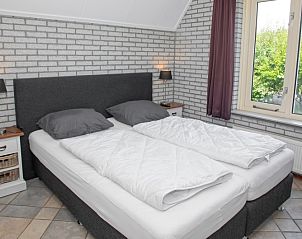 Bedroom with double bed in Holiday home Schelpenoord 121, De Cocksdorp Texel, offers a quiet atmosphere.