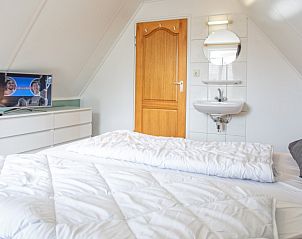 Bright bedroom with TV and sink in Holiday home Schelpenoord 121, De Cocksdorp Texel.