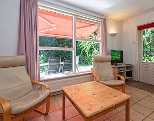 Wohnzimmer des Ferienhauses Slufterduin 088 in De Cocksdorp, Texel, mit groen Fenstern und Zugang zum Garten.