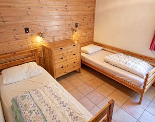 Zweites Schlafzimmer im Ferienhaus Slufterduin 088, Texel, mit zwei Einzelbetten und Holzelementen.