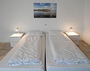 Gemtliches Schlafzimmer im Ferienhaus Slufterduin 098, Texel, mit zwei Einzelbetten und Nachtlicht.