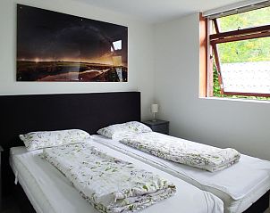Schlafzimmer im Ferienhaus Slufterhoek 178, De Cocksdorp, Texel mit Doppelbett und Fenster mit Aussicht.