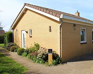 Vorderansicht des Ferienhauses Slufterhoek 076 in De Cocksdorp Texel mit bunten Blumen.