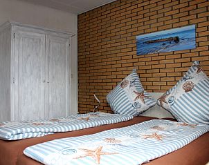 Hauptschlafzimmer im Ferienhaus Slufterhoek 076 De Cocksdorp Texel mit Doppelbett und Stranddekor.