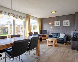 Gerumiges Esszimmer und Wohnzimmer im Ferienhaus Slufterhoek 056, De Cocksdorp, Texel, mit viel Tageslicht und Blick auf den Garten.