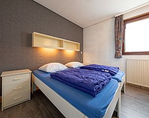 Komfortables Schlafzimmer im Ferienhaus Slufterhoek 056, De Cocksdorp, Texel, mit Doppelbett und stimmungsvoller Beleuchtung.