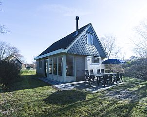Auenbereich des Sluftervallei 8-Personen-Bungalows 8C in De Cocksdorp, Texel mit sonniger Terrasse und Gartenmbeln.