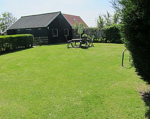 Large garden at De Vlinder, vacation home in De Cocksdorp, Texel, with seating and surrounding nature.
