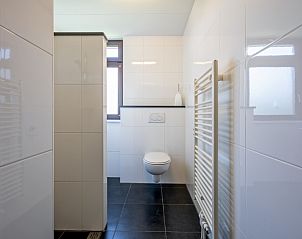 Ruime badkamer met toilet en moderne tegels in Vakantiehuis Slufterhoek 078, Texel.
