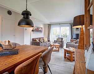 Stylish dining room in Krimweg 051 vacation home, De Cocksdorp Texel, with wooden table and comfortable chairs.