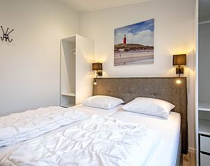 Comfortable bedroom in Krimweg 051 vacation home, De Cocksdorp Texel, with double bed and wall decoration.