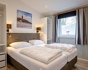 Bedroom with double bed in Krimweg 051 vacation home, De Cocksdorp Texel, with lots of natural light.