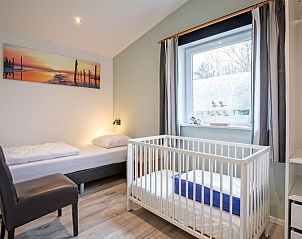 Children's room with crib in Krimweg 051 vacation home, De Cocksdorp Texel, ideal for families.
