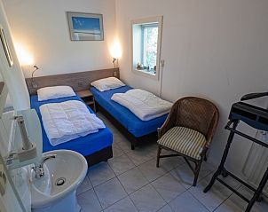 Schlafzimmer mit zwei Einzelbetten in Bungalowpark Slufteroord Holiday home 300, De Cocksdorp, Texel.