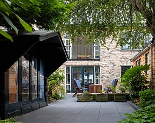 Spacious patio at Het Kwade Konijn, vacation home in De Cocksdorp, Texel, with seating and surrounded by nature.