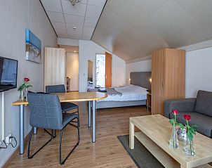 Modern living room in Type 1 - 2100 vacation home, De Cocksdorp, Texel, with comfortable sofa and dining table.