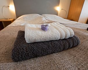 Soft towels and soap on bed in Type 1 - 2100 vacation home, De Cocksdorp, Texel, for extra comfort.
