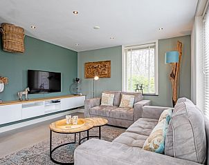 Gezellige woonkamer in Bungalow Postweg 109, De Cocksdorp, Texel. Comfortabele zitruimte ideaal voor ontspanning op de Waddeneilanden.